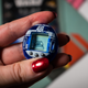 A photo of a person holding the R2-D2 Tamagotchi